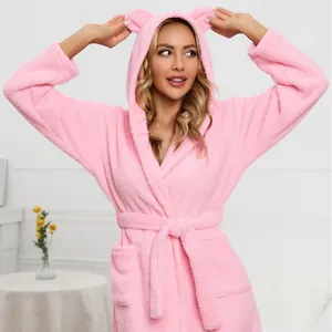 Close-up of pink plush hooded bathrobe with cute bear ears and soft fleece texture.