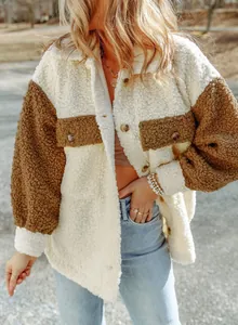 Dettaglio di giacca in pile sherpa color-block con tasche a bottone per l'autunno.