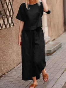 Close-up of a casual black two-piece set featuring a loose shirt and wide-leg trousers