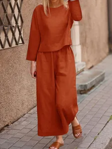 Casual orange linen-style two-piece set for women shown in an outdoor street setting