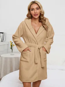 Detail showing a soft beige hooded plush bathrobe with a secure waist belt and pockets