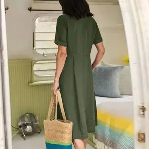 Back view of a woman wearing a green linen dress in a cozy camper interior