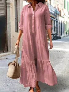 Full length pink cotton linen shirt dress with ruffled hem in casual street style.