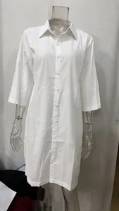 Loose white linen-cotton shirt dress featuring lapel buttons and mid-length sleeves.