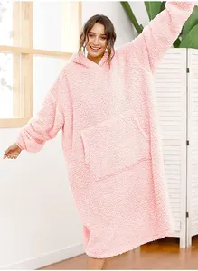 Cozy oversized pink sherpa fleece hoodie blanket worn by a model in a bright room