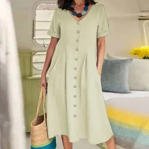 Detail view of a loose beige cotton linen dress with a button-down V-neck