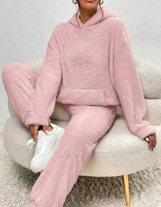 Detailed view of a soft pink fuzzy two-piece lounge set with hooded top and pants.
