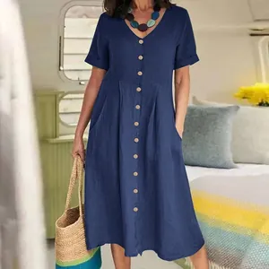 Detail shot showing the pleated high waist and button-down front of a casual blue linen dress