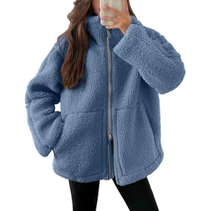 Detailopname van een blauwe oversized teddy fleece jas met rits en hoge kraag