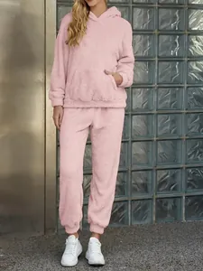 Full-body view of a cozy pink fleece hooded lounge set with pocket and matching pants.