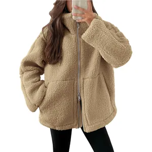 Detailweergave van de zachte beige sherpa fleece textuur en de ritssluiting met kraag