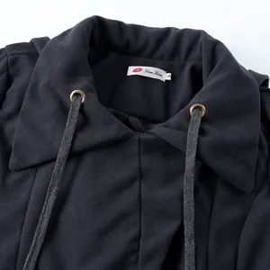 Close-up detail of black double-sided wool coat with drawstrings and metal eyelets.