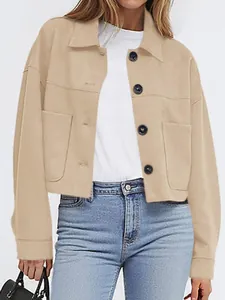 Detail showing the front view of a women's beige faux suede cropped jacket with buttons.