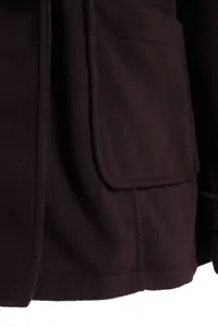 Macro view showing the pocket detail and thick fabric texture on women's dark wool coat