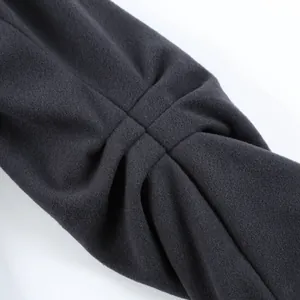Detailed close-up showing the pleated fabric texture of a dark grey women's woolen coat