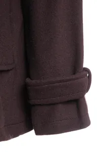 Close-up detail of a dark purple thick wool coat sleeve showing the decorative strap