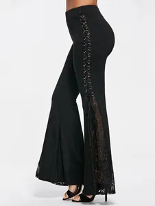 Detail van zwarte punkstijl flare broek met vetersluiting aan de zijkant en kantpaneel.