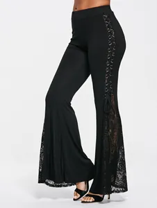Detail van een zwarte punkstijl flare broek met vetersluiting en zijdelingse kant