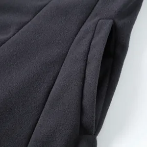 Detail of a charcoal wool-blend coat showing the clean stitching and side pocket design