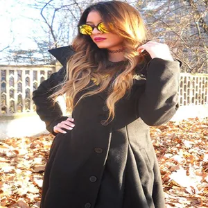 Detailed view of women's black double-sided woolen trench coat with irregular hem in autumn setting