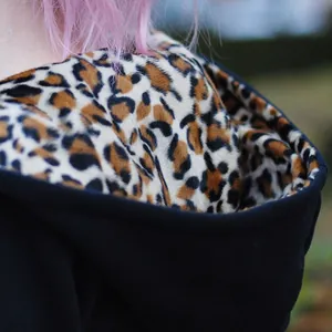 Close-up of soft plush leopard print lining inside the hood of a black fleece hoodie