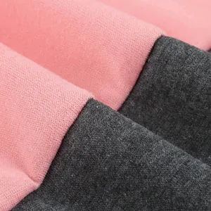 Dettaglio ravvicinato della trama del tessuto rosa e grigio antracite della felpa.