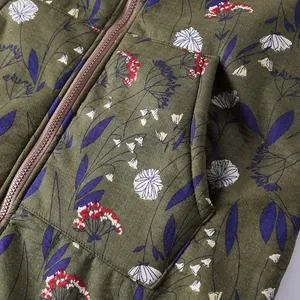 Close-up detail of the floral print and zipper on a green padded winter coat