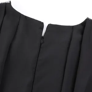 Detailansicht eines schwarzen Chiffonkleides mit silbernen Pailletten und Reißverschluss