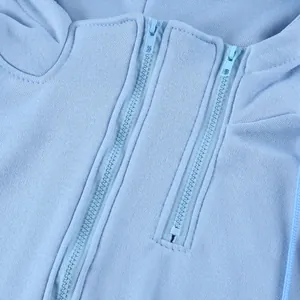 Dettaglio dell'esclusivo design a doppia cerniera sulla felpa con cappuccio azzurra