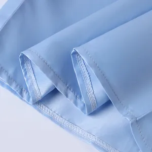Close-up of the professional double-stitched hemline on a light blue dress