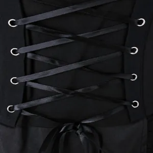 Détail du laçage en ruban noir avec œillets métalliques argentés sur robe vintage