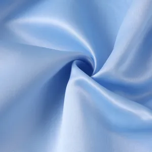 Macro view of light blue satin fabric texture with soft silk sheen