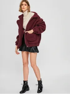 Dettaglio della morbida trama di una giacca in pile sherpa color bordeaux con tasche