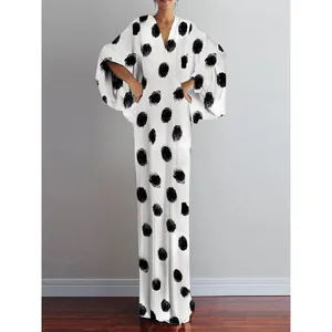 Detail view of retro white maxi dress with large black polka dots and V-neck line