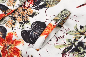 Close-up of floral print fabric with a wooden button and pocket on a cotton coat