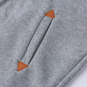 Dettaglio ravvicinato di felpa in pile grigio con tasche e toppe in pelle