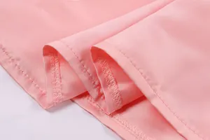 Detail macro view showing the precise overlock stitching on the pink fabric hemline