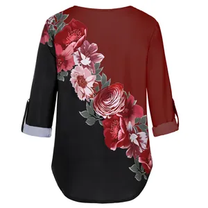 Detail of the vibrant floral print and 3/4 tab sleeves on this color-block blouse.