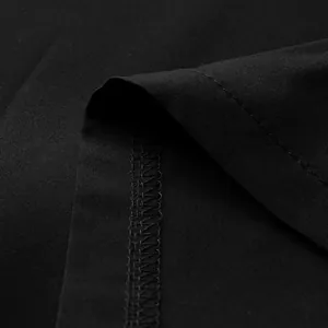 Gros plan sur la texture du tissu noir et la couture surjetée professionnelle d'un ourlet de robe