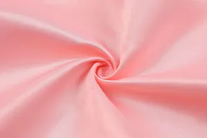 Close-up macro view of the silky pink satin fabric texture for elegant evening gowns