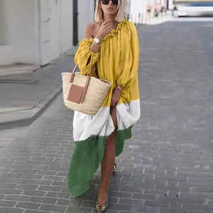 Vue détaillée d'une robe longue ample à épaules dénudées jaune, blanche et verte.