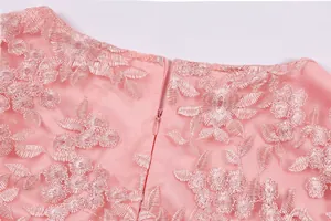 Close-up of intricate pink floral lace embroidery and hidden zipper detail on dress