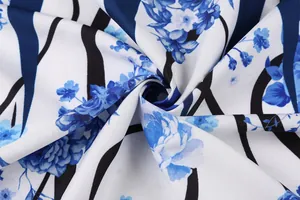 Nahaufnahme von Vintage-Stoff mit blauem Blumenmuster und schwarzen Streifen auf Weiß.