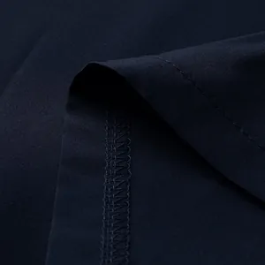 Gros plan macro détaillé montrant les coutures fines et la texture du tissu de la robe