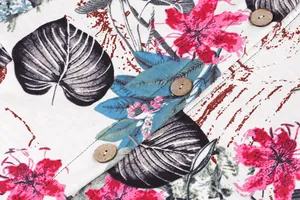 Close-up of tropical floral print fabric with natural wooden buttons on a casual jacket