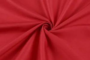 Macro shot showing the fine weave and smooth texture of high-quality red summer dress fabric