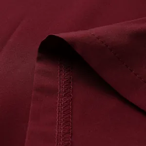 Gros plan d'une robe rétro bordeaux montrant les coutures fines et la texture du tissu.