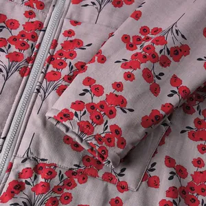Detailed macro view showing red floral pattern and zipper of women's warm winter coat.