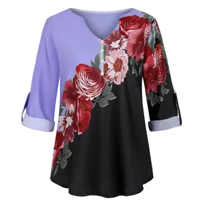 Detailed view of the V-neck floral print blouse with roll-tab sleeves and vintage pattern.