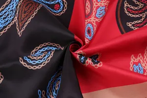 Gros plan sur un tissu à imprimé paisley et chaîne vintage en blocs de rouge et noir